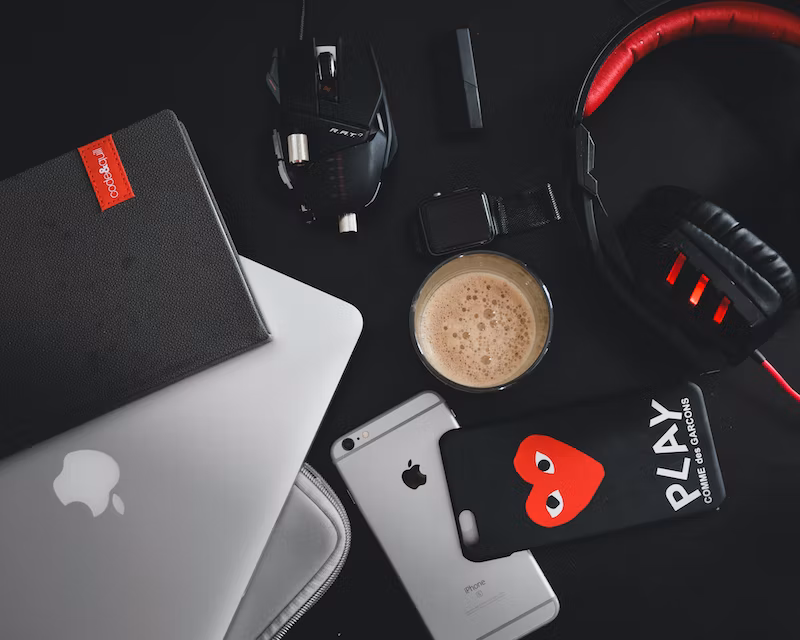 Imagem de computador, smartphone, fone, em cima de uma mesa com café